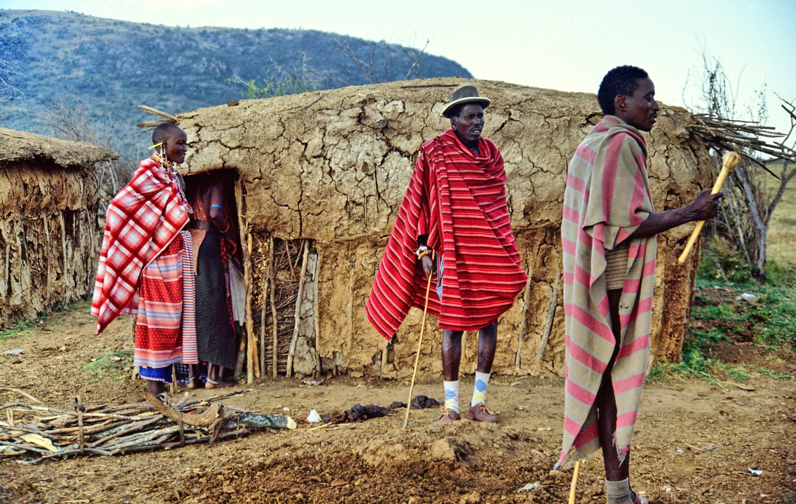 Regional context for Topi Mara Bush Camp profile: Maasai people beside a traditional homestead; not the camp