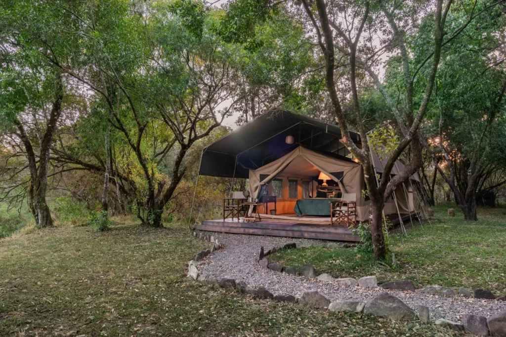Tor's Camp Mtoni canvas tent on a raised deck beneath riverine trees