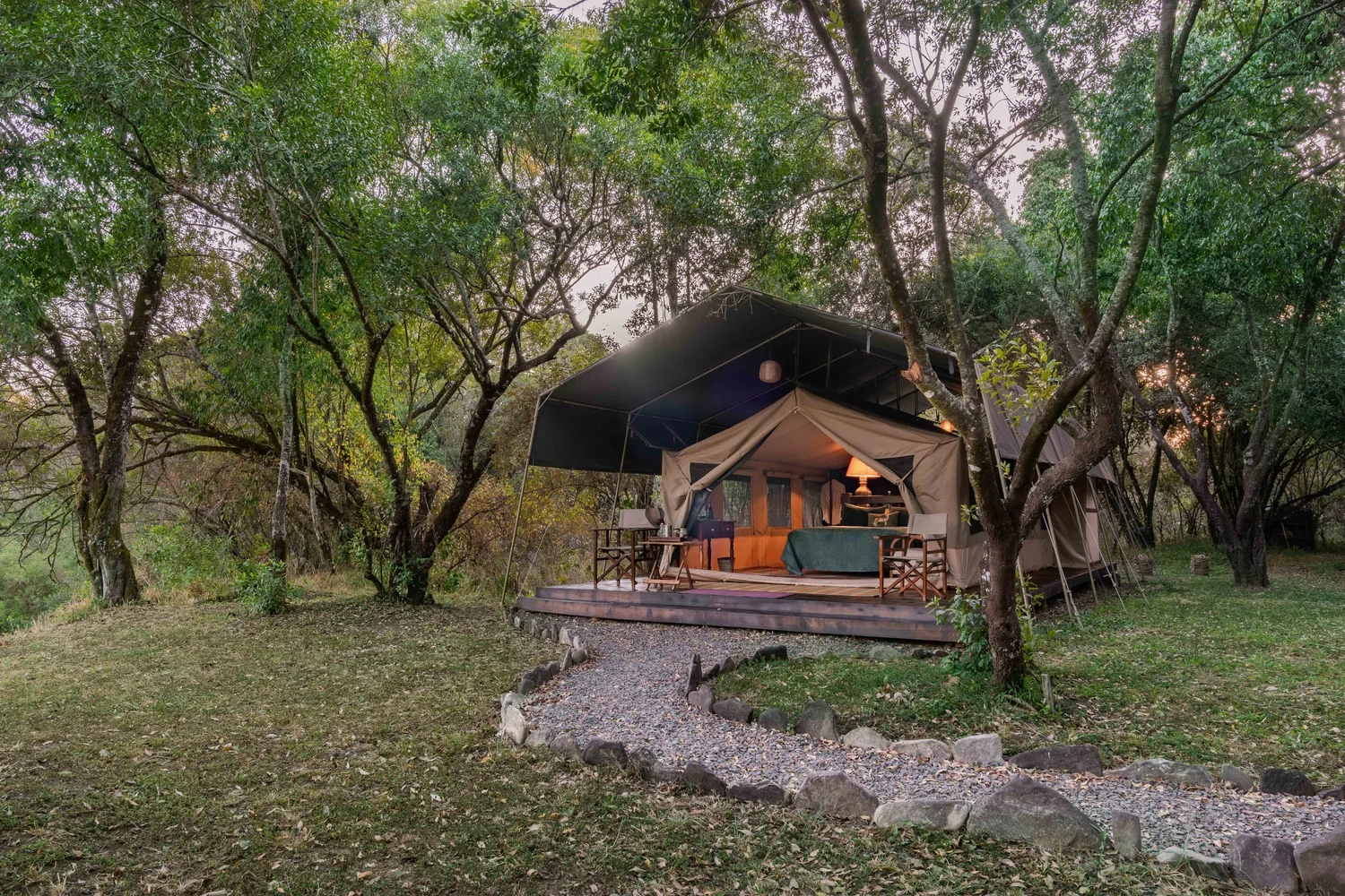 Tor's Camp Mtoni canvas tent on a raised deck beneath riverine trees
